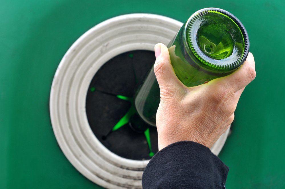 Someone,Putting,A,Glass,Bottle,In,A,Recycling,Container
